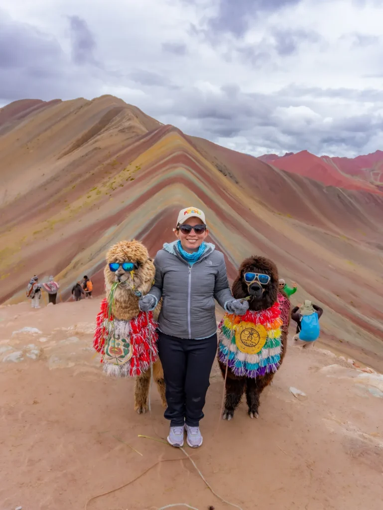 Viajera junto a llamas decoradas en la Montaña de Colores Vinicunca