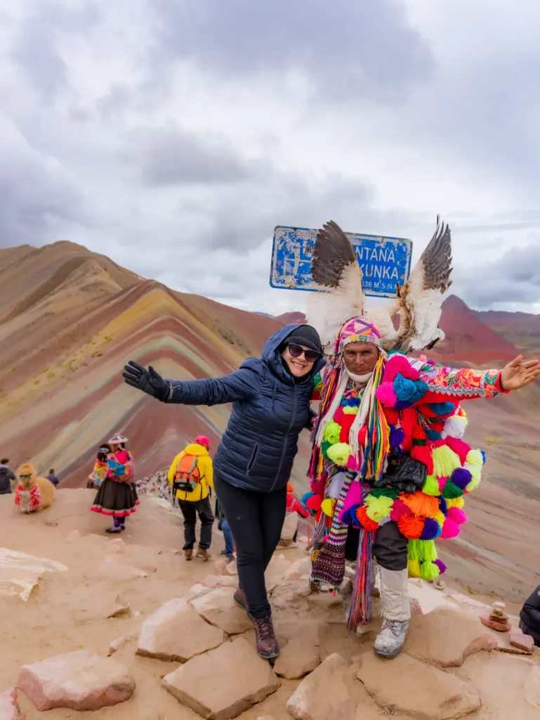 Viajera con un poblador andino en traje típico en la Montaña de Colores Vinicunca